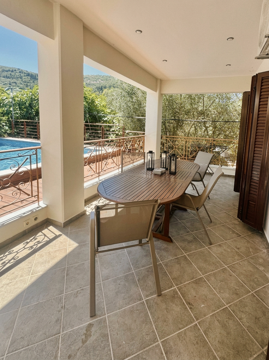Covered veranda with dining table beside the pool